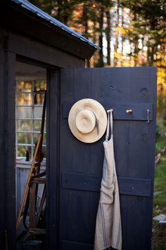 a hat hanging on the side of a blue shed