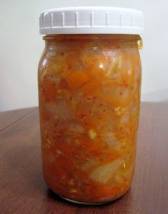 a jar filled with food sitting on top of a wooden table