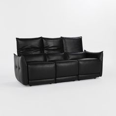 a black leather couch sitting on top of a white floor