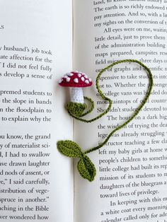 a crocheted bookmark made to look like a mushroom on top of an open book