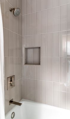 a white bath tub sitting next to a shower head