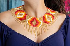 a woman wearing a beaded necklace and earrings