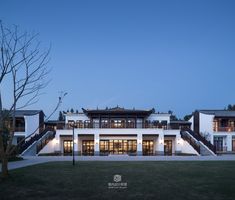 a large white building with stairs leading up to it's second story and two levels