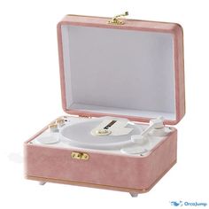 a pink and gold record player sitting inside of a case