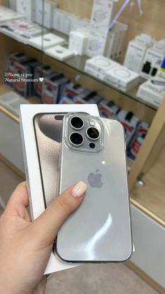 a person holding an iphone in their hand with the box open and it's inside