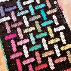 a crocheted blanket with different colored crosses on it