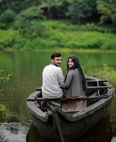 a man and woman are sitting in a boat on the water, smiling at each other