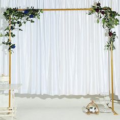 the wedding cake is on top of a stand with flowers and greenery around it