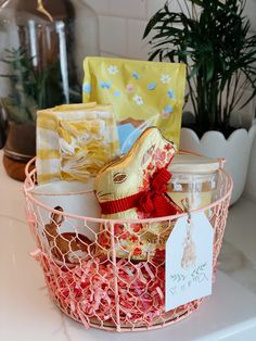 a basket filled with lots of different types of wrapped presents on top of a counter