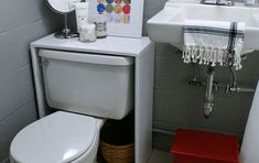 a white toilet sitting next to a sink in a bathroom