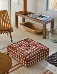 a living room filled with furniture and a wooden coffee table next to a vase on top of a hard wood floor