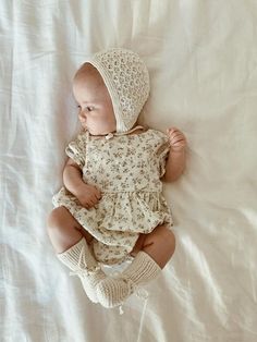 a baby is laying down wearing a bonnet and diapers on it's head