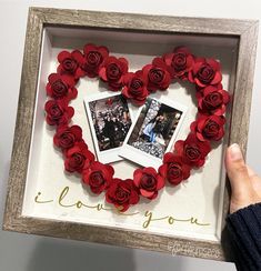 someone holding up a heart shaped frame with roses in the shape of two pictures and i love you written on it