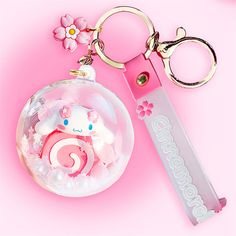 a keychain with an animal inside of it and a flower on the side