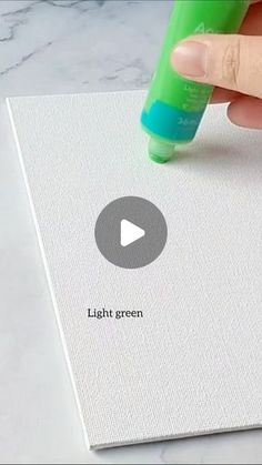 a hand is holding a marker over a piece of paper with the word light green on it