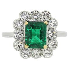 This is a wonderful emerald and diamond cluster ring. The ring features a central emerald cut Zambian emerald which possesses a beautifully intense green tone which is highly complimented by the bright white round brilliant cut diamonds which circulate the outer edge. The ring has been crafted in platinum but the emerald has been set in yellow gold to bring out the intense colour. Condition: Used (Very Good) Weight: 6.4 grams Size: P Emerald Dimensions: 8.4mm x 6.7mm Total Diamond Carat Weight: Approx. 1.20 carats Diamond Details: Colour: F-H Clarity: VS-SI Hallmarked: London 2001 Period: Modern Box: The Vintage Jeweller Ring Box Comments: These diamonds/gemstones have not been certified by a laboratory, they have been graded by our own qualified gemologists as fairly and as accurately as Green Tone, Zambian Emerald, Diamond Carat, Green Tones, Diamond Cluster Ring, Zambia, Emerald Diamond, Diamond Cluster, Ring Vintage