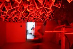 a room with red lights and lots of pictures hanging from the ceiling, all over it