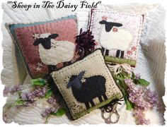 three pillows with sheep on them sitting next to each other