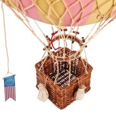 a hot air balloon that is in the shape of a basket with two flags hanging from it