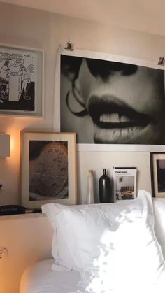 a bed with white pillows and pictures on the wall