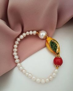 Sicilian bracelet made of: - Freshwater Pearls (6 mm), white color; - Sicily Ceramic Lemon (30 mm x 16 mm); - Mallorca Pearl (12 mm), white color; - Mallorca stone (12 mm), red color. * SHIPPING * Your order will be shipped within 1-3 business days from your purchase. You can choose between 2 shipping methods: STANDARD MAIL (NOT TRACEABLE) It is a cheap and fast shipping method, but NOT TRACEABLE. Chapeau Atelier is not responsible for any postal disruptions, delays or losses. REGISTERED MAIL (T Classic White Pearl Bangle Bracelet, White Single Strand Round Bracelet, White Round Single Strand Bracelet, White Single Strand Beaded Bracelet For Gift, White Single Strand Bracelet As A Gift, White Single Strand Bracelet Gift, Classic White Bracelet As A Gift, Classic White Handmade Bracelets, Classic White Bracelet For Gift