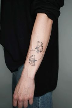 a person with a black and white tattoo on their arm, holding onto the wrist