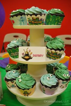 cupcakes with green frosting are stacked on top of each other at a children's birthday party