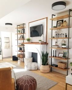 a living room filled with furniture and a flat screen tv mounted on a wall above a fire place