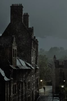 a black and white photo of people walking in the rain on a dark city street