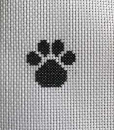 a cross stitch pattern with a black and white dog paw on it's side