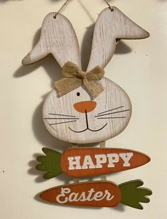 a wooden sign that says happy easter hanging on a wall