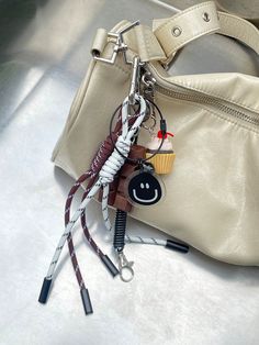 a purse with some keys attached to it and a cupcake hanging from the handle