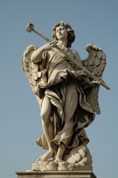 an angel statue holding a staff and wearing a crown