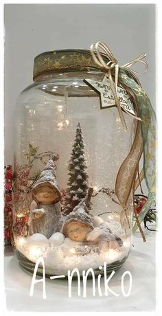 a glass jar filled with snow covered rocks and trees