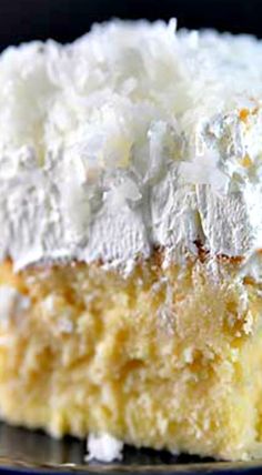 a piece of cake with white frosting on top sitting on a blue and silver plate