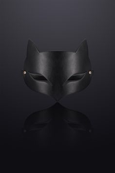 a black leather mask with gold eyes on a dark background, the image is made up of