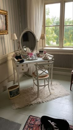 a room with a desk, mirror and rug on the floor