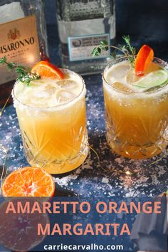 two glasses filled with orange margaritas on top of a table