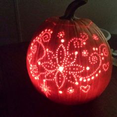 a lighted pumpkin sitting on top of a table