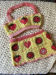 two crocheted purses sitting on top of a blanket