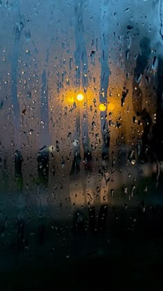 rain drops on the window as people walk by