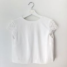 a white top hanging on a hanger