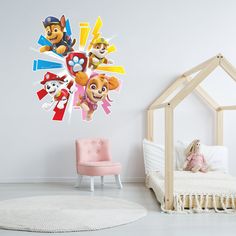 a child's bedroom with a wall decal featuring paw patrol and other cartoon characters