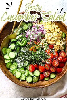 a wooden bowl filled with cucumber salad on top of a white tablecloth