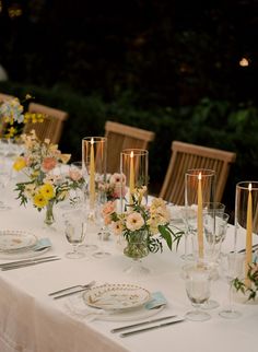 a long table is set with flowers and candles for an elegant dinner or reception party