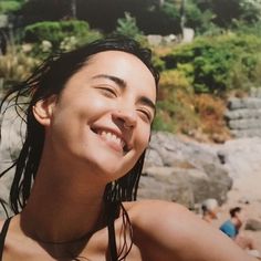 a woman with wet hair smiles at the camera