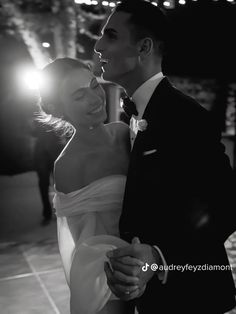 black and white photograph of a bride and groom dancing at their wedding in the evening