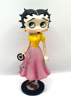 a small figurine is standing on a white surface with a black hair and green eyes