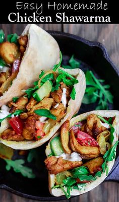 three tacos filled with meat and veggies on top of a black plate