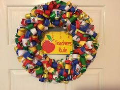 a teacher's rules wreath hanging on the front door with an apple for back to school